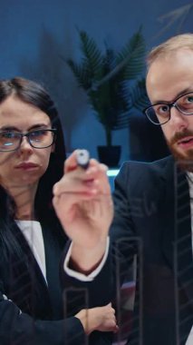 İyi görünümlü, çalışkan, zeki, ısrarcı iki iş kadını ve onların sakallı meslektaşlarının, akşam çalışma odasındaki cam panoda plakları kullanarak iş konsepti üzerine beyin fırtınası yaptıkları bir iş konsepti.