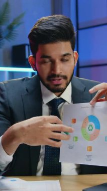 İyi görünümlü, başarılı, deneyimli, takım elbiseli iş adamı. Video konferansı sırasında iş arkadaşlarıyla kameraya bilgi aktarıyor.