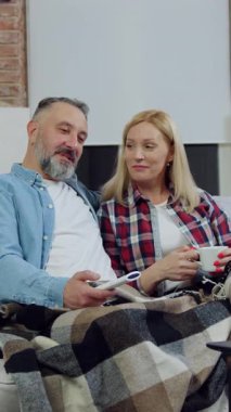 Sevimli, pozitif, mutlu, 40-50 yaşlarında, sarışın bir kadın ve sakallı bir adam. Hoş bir dairede rahat koltukta oturmuş sohbet ediyor ve dizüstü bilgisayardan eğlenceli programlar izliyorlar.