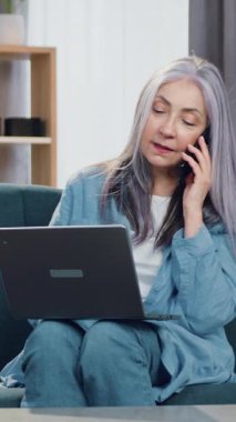 Çekici bir gülümseme. 65 yaşında, kendinden emin, zeki bir kadın. Rahat bir kanepede rahat bir şekilde oturuyor.