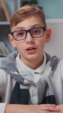 Kapalı portre küçük çocuk evde masada oturup kameraya bak köylü gibi uzaktan sohbet ediyor..