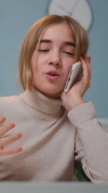 Gorgeous 10 years old schoolgirl answers the call phone sitting the table at living room. Preteen girl talking the phone at home. Slow motion