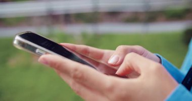 Kadın elinin yakın çekimi telefon kullanıyor. Cep telefonu kullanan ya da sohbet eden kadın eller. Açık havada.