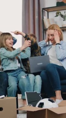 Sevimli heyecanlı komik erkek ve kız kardeşler yeni evlerinin tasarımı hakkında tartışıyorlar, sakallı baba ve sarışın anne ile koltukta oturuyorlar, ebeveynler tartışmaları dinlemek istemedikleri için başlarından tutuyorlar.