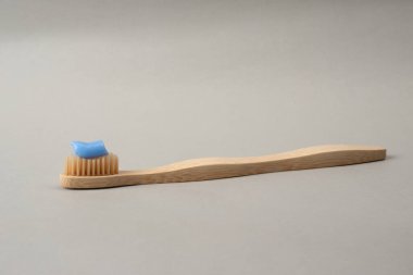 Gri arka planda çevre dostu Bambu diş fırçası. Oral bakım konsepti. Ekolojik Sağlık Aksesuarları