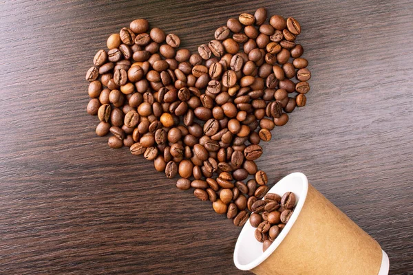 Heart shape made from coffee beans. Roasted Coffee beans background close up. International coffee day concept