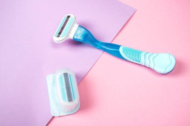 Pembe arka planda izole edilmiş, değiştirilebilir kartuşlu kadın jileti. Yakın plan. Güzellik konsepti