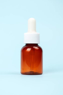 Mavi arka planda izole edilmiş kozmetik şişesi. Tasarım için konteynırı taklit et. Tıbbi ve kozmetik konsepti