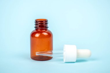 Mavi arka planda izole edilmiş kozmetik şişesi. Tasarım için konteynırı taklit et. Tıbbi ve kozmetik konsepti