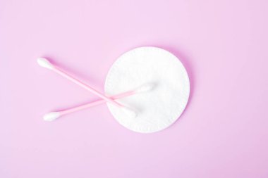 Pamuklu bez ve pamuklu ped pembe arka planda izole edilmiş. Güzellik ve hijyen kavramı