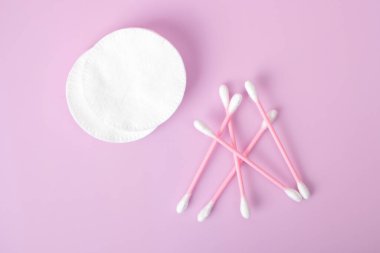 Pamuklu bez ve pamuklu ped pembe arka planda izole edilmiş. Güzellik ve hijyen kavramı