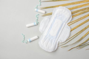 Gri arka planda hijyenik ped ve tampon izole edilmiş. Güzellik ve hijyen kavramı