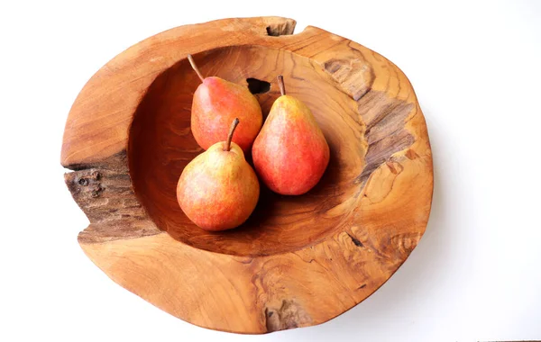 Tres peras en un tazón de madera de teca sobre un fondo blanco.Alimento natural. Fruta para jugos y gelatinas.Concepto de frutas. — Foto de Stock