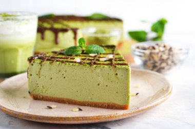 Beyaz arka planda Japon yeşil kibrit çaylı cheesecake.