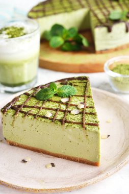 Beyaz arka planda Japon yeşil kibrit çaylı cheesecake.