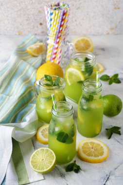 Limonlu nane limonatası ve beyaz arka planda limon