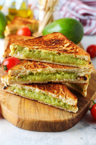 Avocado grilled cheese sandwich on white background