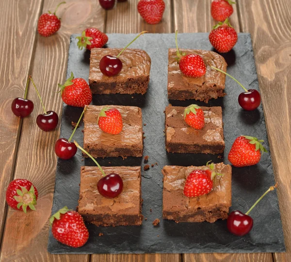 Chocolade brownies met aardbeien en kersen Stockfoto