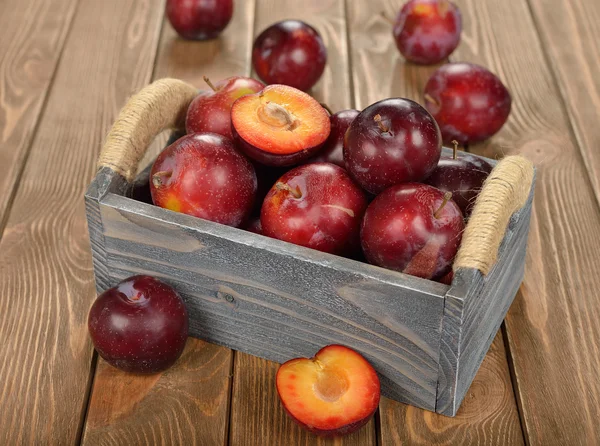 Fresh plums in a wooden box — Stock Photo, Image