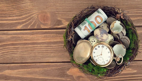 Uhren, Geld und Eier im Nest — Stockfoto