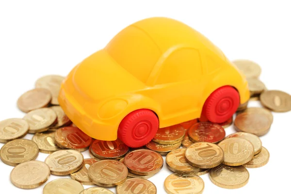 Toy auto stand on pile of coins (isolated) — Zdjęcie stockowe