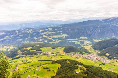 İtalya, Alpe di Siusi, Seiser Alm ve Sassolungo Langkofel Dolomite, yemyeşil bir tepe manzarası.