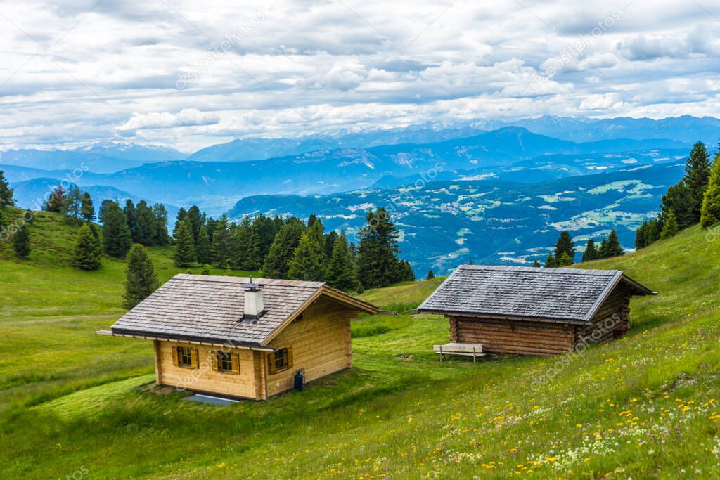 Italy, Alpe di Siusi, Seiser Alm with Sassolungo Langkofel Dolomite, a house with a mountain in the background