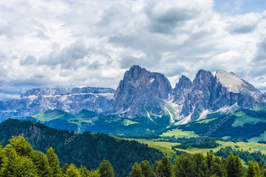 Italy, Alpe di Siusi, Seiser Alm with Sassolungo Langkofel Dolomite, a view of a large mountain in the background