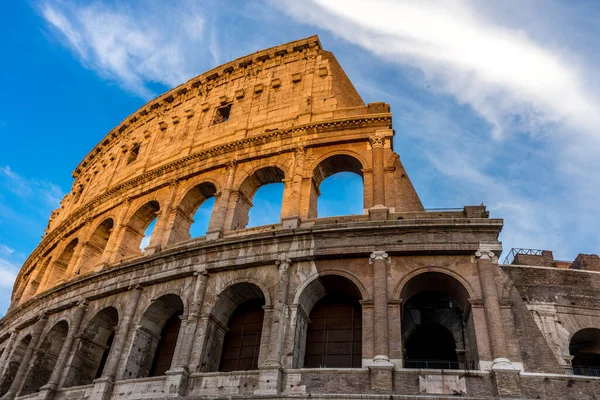 Golden sunset at the Great Roman Colosseum (Coliseum, Colosseo), also known as the Flavian Amphitheatre. Famous world landmark. Scenic urban landscape.