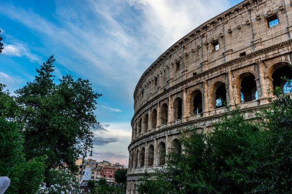 Golden sunset at the Great Roman Colosseum (Coliseum, Colosseo), also known as the Flavian Amphitheatre. Famous world landmark. Scenic urban landscape.