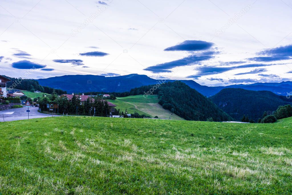 Italy, Alpe di Siusi, Seiser Alm with Sassolungo Langkofel Dolomite, a large green field with a mountain in the background