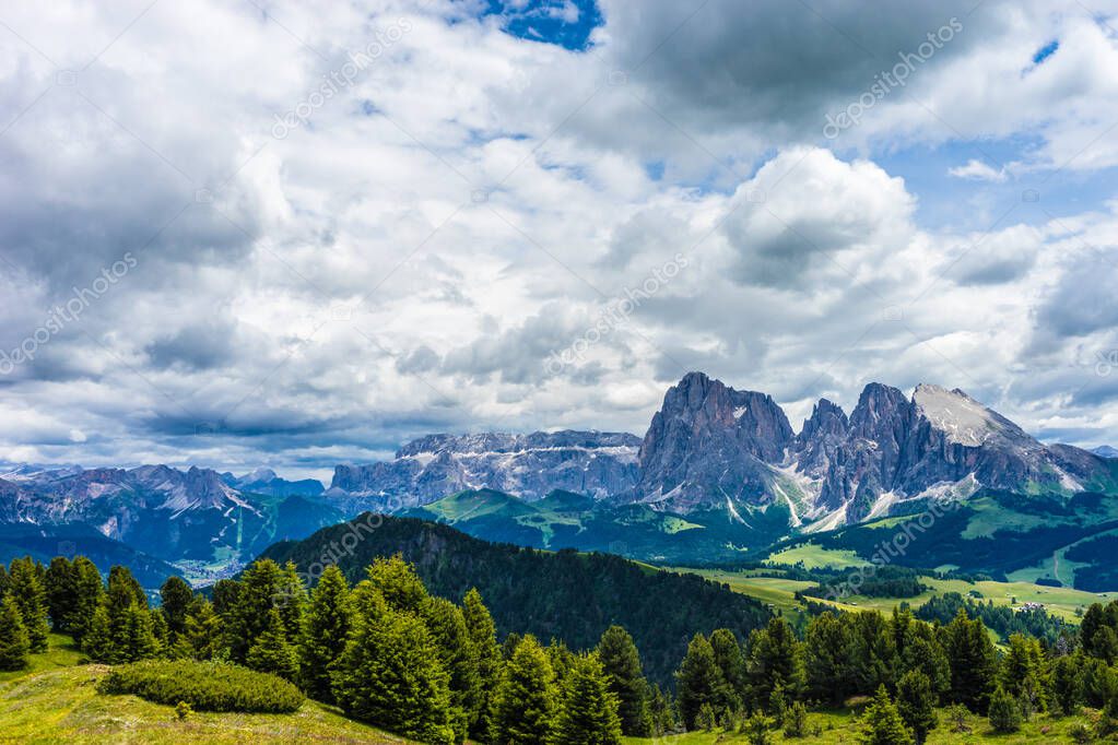 Italy, Alpe di Siusi, Seiser Alm with Sassolungo Langkofel Dolomite, a view of a large mountain in the background