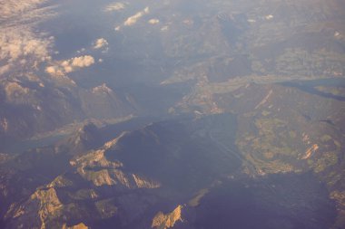 Avrupa 'da bir uçak penceresinden görülen Avusturya Alp Dağları karla kaplı bulutlar