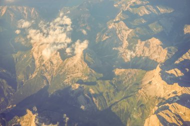 Avrupa 'da bir uçak penceresinden görülen Avusturya Alp Dağları karla kaplı bulutlar