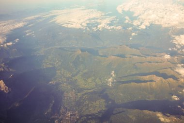 Avrupa 'da bir uçak penceresinden görülen Avusturya Alp Dağları karla kaplı bulutlar