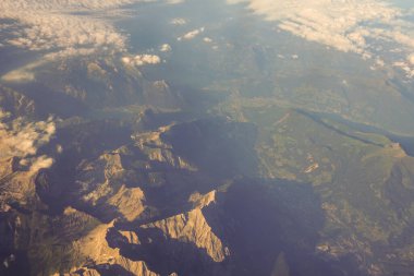 Avrupa 'da bir uçak penceresinden görülen Avusturya Alp Dağları karla kaplı bulutlar