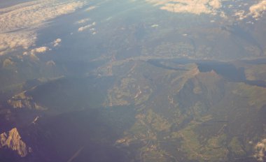 Avrupa 'da bir uçak penceresinden görülen Avusturya Alp Dağları karla kaplı bulutlar