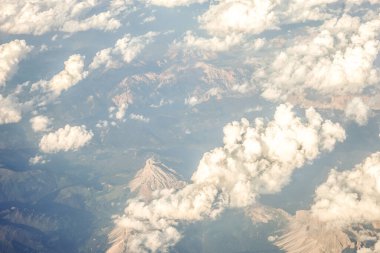 Avrupa 'da bir uçak penceresinden görülen Avusturya Alp Dağları karla kaplı bulutlar