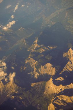 Avrupa 'da bir uçak penceresinden görülen Avusturya Alp Dağları karla kaplı bulutlar