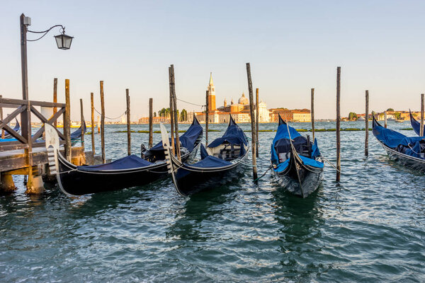 Gondolas moored by Saint Mark square with San Giorgio di Maggiore church in the background in Venice, Italy