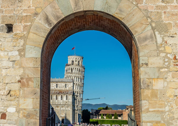 The leaning tower of pisa viewed through entrace arch of Piazza dei Miracoli