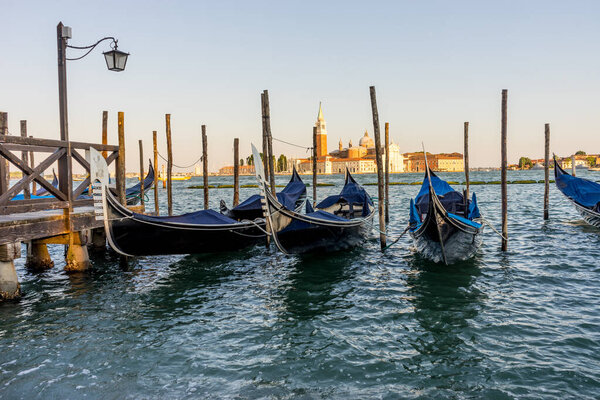 Gondolas moored by Saint Mark square with San Giorgio di Maggiore church in the background in Venice, Italy