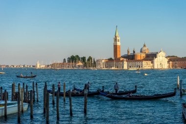 Venedik, İtalya - 30 Haziran 2018: Venedik, İtalya 'da arka planda Saint Mark Meydanı ve San Giorgio di Maggiore Kilisesi' nin demirlediği Gondolas