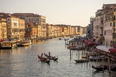 Venedik, İtalya - 30 Haziran 2018: Gondolcu, İtalya 'nın Venedik kentindeki Rialto Oteli yakınlarındaki büyük kanalda turistleri gezintiye çıkarıyor