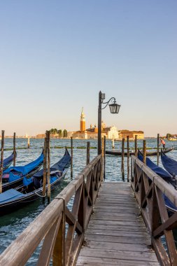 Venedik, İtalya - 30 Haziran 2018: Venedik, İtalya 'da arka planda Saint Mark Meydanı ve San Giorgio di Maggiore Kilisesi' nin demirlediği Gondolas