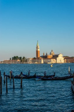 Venedik, İtalya - 30 Haziran 2018: Venedik, İtalya 'da arka planda Saint Mark Meydanı ve San Giorgio di Maggiore Kilisesi' nin demirlediği Gondolas