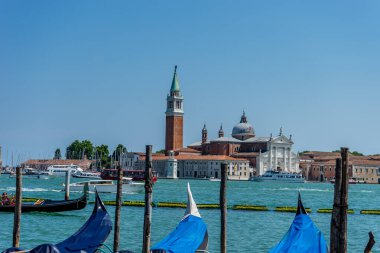 Venedik, İtalya - 01 Temmuz 2018: Venedik, İtalya 'da arka planda Saint Mark Meydanı ve San Giorgio di Maggiore Kilisesi' nin demirlediği Gondolas