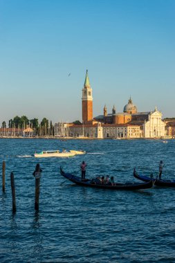 Venedik, İtalya - 30 Haziran 2018: Venedik, İtalya 'da arka planda Saint Mark Meydanı ve San Giorgio di Maggiore Kilisesi' nin demirlediği Gondolas