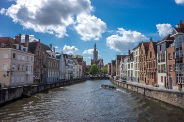 Koningstraat Köprüsü, Brugge, Belçika 'dan ünlü Jan van Eyckplein' in parlak güneşli bir günde mavi gökyüzü...