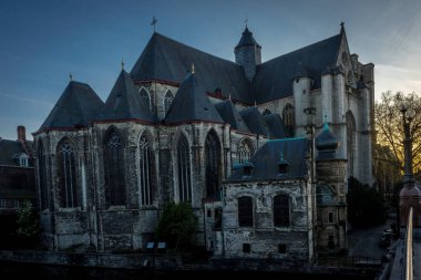 Altın güneş Gent, Belçika, Avrupa 'daki St.Nikolas kilisesinin arkasında batıyor.